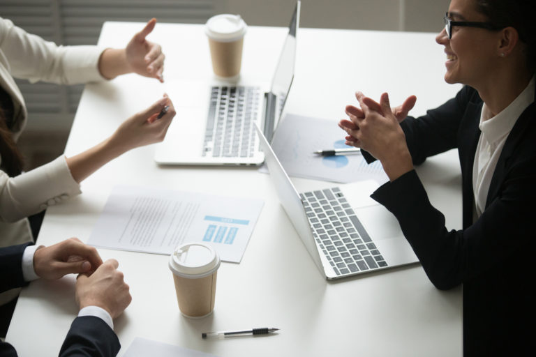 Smiling businesswoman enjoying talk with colleagues during teamw